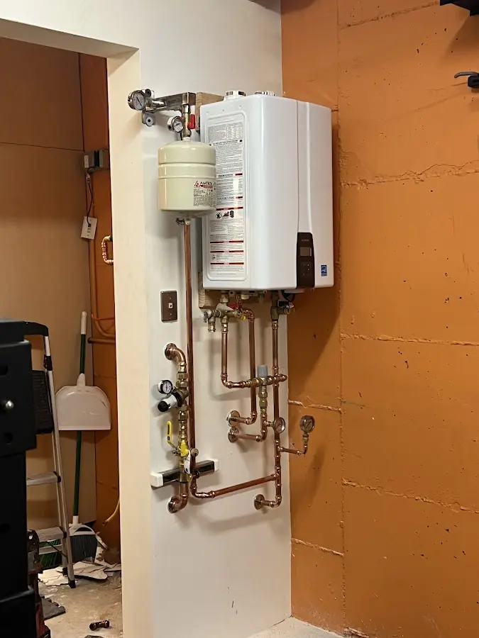Plumbing technician inspecting water heater connections in Willmar